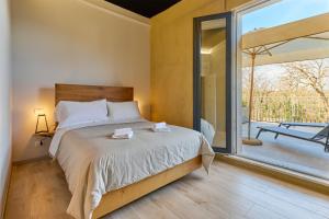 a bedroom with a bed and a large window at La Dama Country Rooms in Monteriggioni