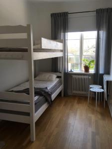 a bedroom with two bunk beds and a window at Vadstena Vandrarhem-Hostel in Vadstena