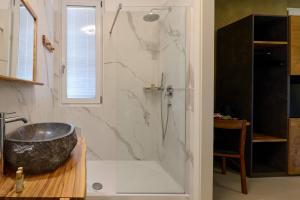 a bathroom with a shower with a large stone tub at La Dama Country Rooms in Monteriggioni