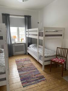 1 Schlafzimmer mit 2 Etagenbetten und einem Stuhl in der Unterkunft Vadstena Vandrarhem-Hostel in Vadstena