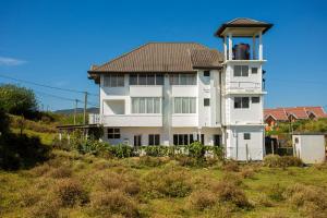 a white building with a control tower on a hill at Country Club Nuwara Eliya in Nuwara Eliya