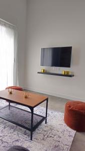uma sala de estar com uma mesa de centro e uma televisão de ecrã plano em Appartement Le New-York em Cholet