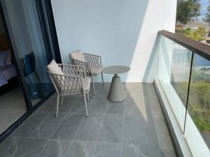 eine Terrasse mit 2 Stühlen und einem Tisch auf dem Balkon in der Unterkunft Freedom Flamingos@Roxy Beach in Lundu