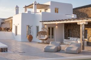 een terras met witte meubels en een wit huis bij Mykonian Icon Villa in Mykonos-stad