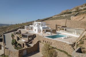 een villa met een zwembad naast een stenen muur bij Mykonian Icon Villa in Mykonos-stad