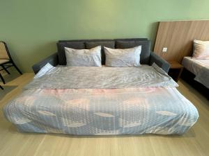 ein großes Bett in einem Zimmer mit einem Bettröckchen. in der Unterkunft Freedom Flamingos@Roxy Beach in Lundu