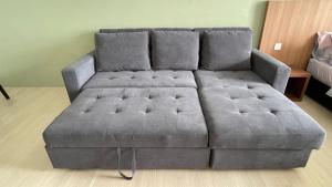 ein großes graues Sofa im Wohnzimmer in der Unterkunft Freedom Flamingos@Roxy Beach in Lundu