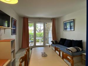 uma sala de estar com um sofá e uma mesa em Ref 006 - Appartement 2 pièces à deux pas de la plage et du port, à louer pour les vacances em Arzon