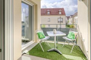 a balcony with a table and two chairs on a balcony at C4 Les Jardins d'Orsonville in Chessy +5 photos