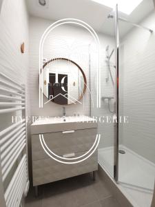 een badkamer met een wastafel en een spiegel bij Hyères : magnifique appartement Le Bois d Olivier in Hyères