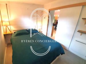 een slaapkamer met een bed met een groen dekbed bij Hyères : magnifique appartement Le Bois d Olivier in Hyères