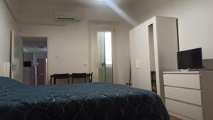 een slaapkamer met een bed en een flatscreen-tv bij BELLA PRIMO PIANO in Forlì