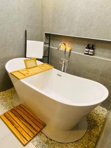 a white bath tub with a faucet in a bathroom at Atia’s Tiny House in General Trias