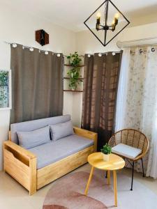 Atia’s Tiny House في General Trias: غرفة معيشة مع أريكة وطاولة