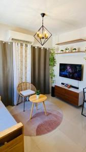 sala de estar con TV y mesa en Atia’s Tiny House en General Trias