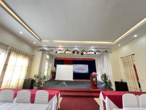 a banquet hall with a stage and a screen at Khách Sạn Hồng Nhung in Yen Bai