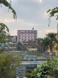 een groot gebouw met een zwembad ervoor bij Khách Sạn Hồng Nhung in Yen Bai