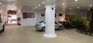 een witte kolom in een kamer met een geparkeerde auto bij Khách Sạn Hồng Nhung in Yen Bai