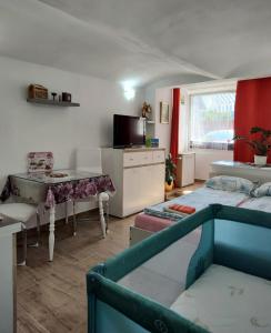 a room with two beds and a table and a kitchen at Apartments Karin in Bled