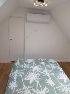 a bedroom with a bed with a green and white blanket at Maison de campagne à la ville in Saint Pavace