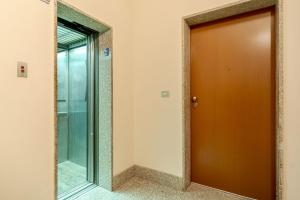 Una puerta marrón en una habitación con espejo en Asti Comentina Railway Functional Flat, en Asti