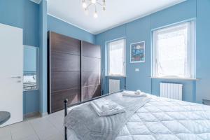 Un dormitorio azul con una cama grande y una lámpara de araña. en Asti Comentina Railway Functional Flat, en Asti