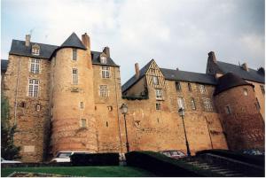 an old castle with cars parked in front of it at Maison de campagne à la ville in Saint Pavace