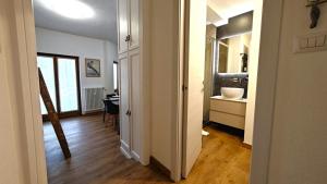 a hallway with a room with a sink and a table at Hostdomus - Royal Oak in Sestriere +9 photos