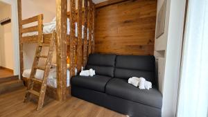a living room with a couch and a bunk bed at Hostdomus - Royal Oak in Sestriere