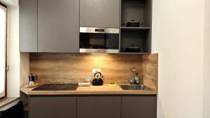 a kitchen with a sink and a microwave at Hostdomus - Royal Oak in Sestriere