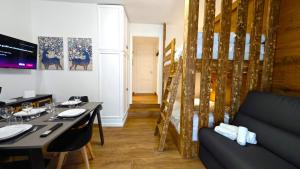 a dining room with a table and a couch and a table and chairs at Hostdomus - Royal Oak in Sestriere