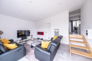 uma sala de estar com um sofá e uma televisão em House Disney Village em Dammartin-sur-Tigeaux