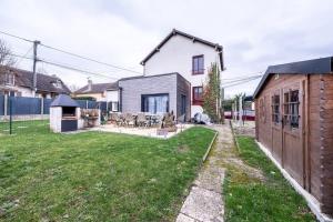 a backyard with a house and a yard with grass at House Disney Village in Dammartin-sur-Tigeaux