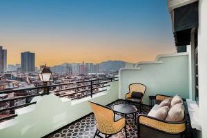 a balcony with chairs and a view of a city at Hotel Central Macau in Macau