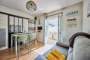 ein Wohnzimmer mit einem Sofa und einem Tisch in der Unterkunft Les Violettes - Appt à 200 m de la plage in Saint-Aubin-sur-Mer