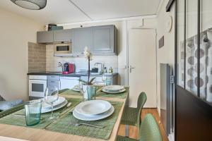 una cucina con un tavolo con sopra dei piatti di Les Violettes - Appt à 200 m de la plage a Saint-Aubin-sur-Mer Altre 5 foto