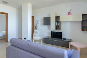 uma sala de estar com um sofá azul e uma televisão em Cintioni a mare 2E - YourPlace Abruzzo em Marina di San Vito