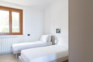 een witte slaapkamer met 2 bedden en een raam bij Cintioni a mare 2E - YourPlace Abruzzo in Marina di San Vito
