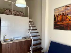 a staircase in a kitchen with a sink and a painting at Apartamentos Balcón de Maro in Maro