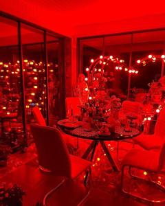 a red room with a table and chairs and lights at Mountain Breeze in Qırızdǝhnǝ