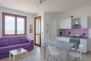 sala de estar con sofá púrpura y mesa en Cintioni a mare C 9 - YourPlace Abruzzo, en Marina di San Vito