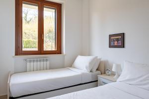 1 dormitorio blanco con 2 camas y ventana en Cintioni a mare C 9 - YourPlace Abruzzo, en Marina di San Vito