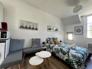 ein Schlafzimmer mit einem Bett, einer Couch und einem Tisch in der Unterkunft V2 Studio Proche Disney Village Nature in Villiers-sur-Morin