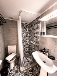 a bathroom with a toilet and a sink at Ten Number Suites in Limenas