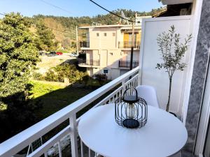 a balcony with a white table and chairs and a view at Ten Number Suites in Limenas