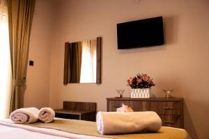 a bedroom with a bed with towels and a television at Ten Number Suites in Limenas