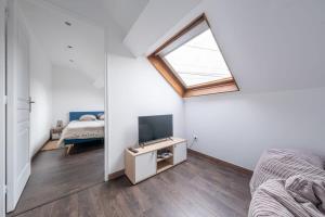 a room with a bed and a tv and a window at D1 Maison de Charme proche Disney Val d'Europe in Dammartin-sur-Tigeaux