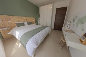 a bedroom with a large bed and a desk at Penthouse With Sunny Terrace in Msida