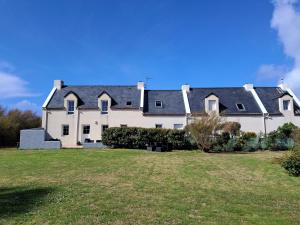 uma grande casa branca com um grande quintal em La Maison des Poulains em Sauzon