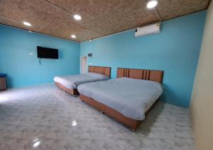 two beds in a room with blue walls at Lsarl Pool Villa อิฏฐ์สรี พูลวิลล่า in Wangkata +24 photos